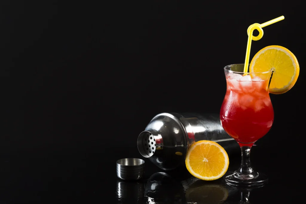 Hurricane cocktail in glass with shaker in background